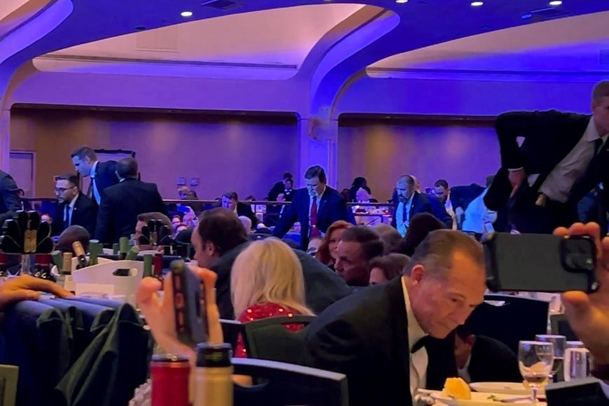 Secret Service agents enter the room to evacuate cabinet members, shortly after U.S. President Donald Trump was escorted out, after a man opened fire with a shotgun on security personnel outside the room during the annual White House Correspondents' Association dinner in Washington, D.C., U.S., April 25, 2026, in this screengrab from a video. REUTERS/Bo Erickson