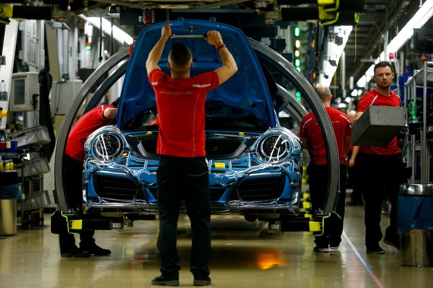 FILE PHOTO: FILE PHOTO: Employees of German car manufacturer Porsche assemble sports cars at the Porsche factory in Stuttgart-Zuffenhausen, Germany, January 26, 2018.   REUTERS/Ralph Orlowski/File Photo/File Photo   Analizan reducir a la mitad el impuesto para los autos cero kilometro que llegan al pais desde Europa Importaciones
