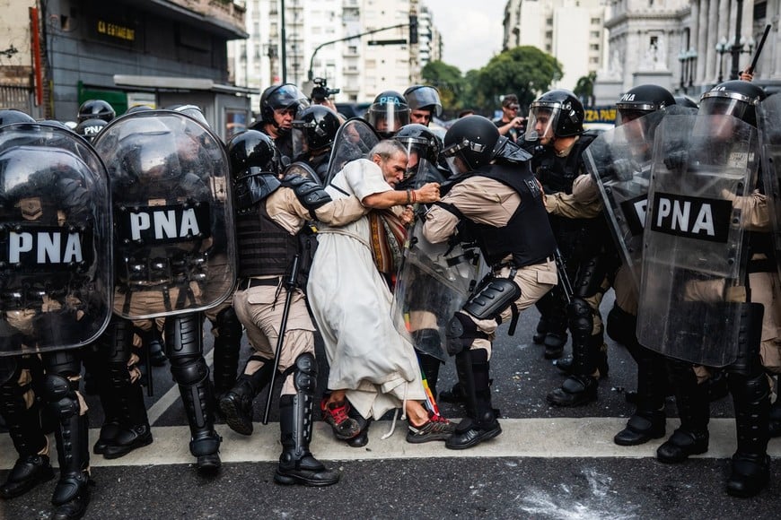Policías argentinos detienen al padre Jorge "Chueco" Romero, que viste hábito religioso, durante una protesta en favor de los jubilados, en Buenos Aires. Premio World Press Photo.