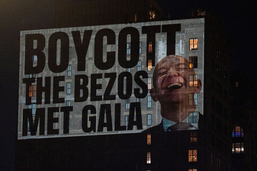 Activists project protest messages, highlighting issues of wealth inequality, climate accountability, and labor rights, onto the facade of a building which can be seen from Jeff Bezos' penthouse, on the eve of the Met Gala, the star-studded fundraiser known for its extravagant fashion and high-profile guests, in New York City, U.S., May 3, 2026. REUTERS/David 'Dee' Delgado   REFILE - ADDING INFORMATION " onto the facade of a building which can be seen from Jeff Bezos' penthouse'