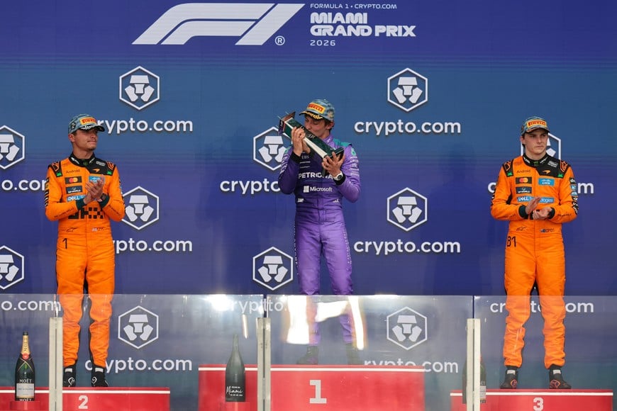 May 3, 2026; Miami Gardens, FL, USA; Mercedes driver Kimi Antonelli (center), McLaren driver Lando Norris (left) and McLaren driver Oscar Piastri (right)  react on the stage for the Crypto.com Miami Grand Prix at Miami International Autodrome. Mandatory Credit: Sam Navarro-Imagn Images