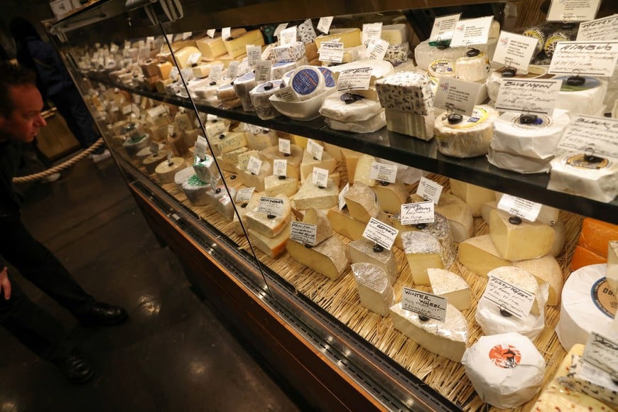 A person looks at a selection of cheeses and price tags in a store in Manhattan, New York City, U.S., March 29, 2022. REUTERS/Andrew Kelly