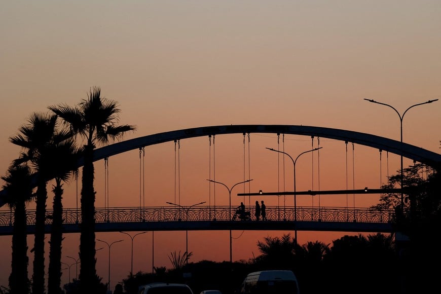 FILE PHOTO: People are silhouetted as they cross a pedestrian bridge during sunset hours, in Islamabad, Pakistan, November 12, 2025. REUTERS/Akhtar Soomro/File Photo