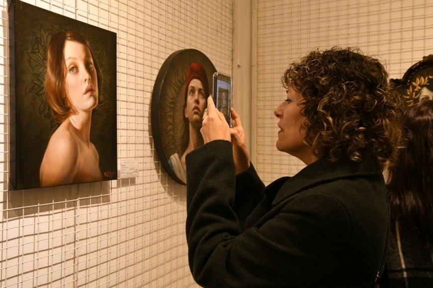 Muestra de Ricardo Celma: Una asistente a la inauguración, fotografiando la pintura “Mailén”.