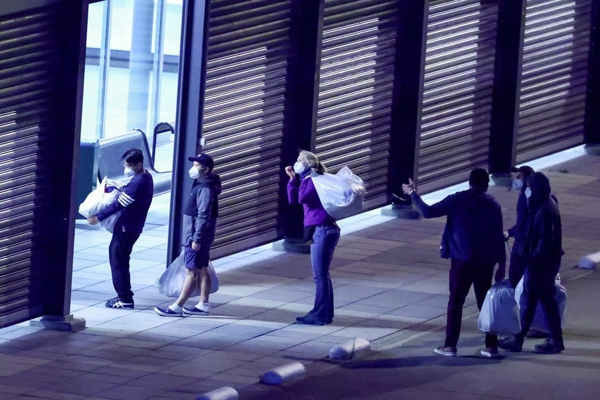 Passengers evacuated from the cruise ship MV Hondius, which was affected by a hantavirus outbreak, walk with their belongings after disembarking at Eindhoven Air Base, Netherlands, May 12, 2026. REUTERS/Piroschka van de Wouw TPX IMAGES OF THE DAY