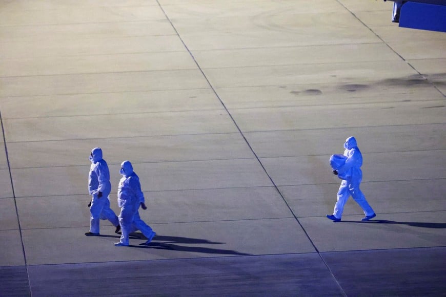 Personnel in hazmat suits walk near a plane carrying passengers evacuated from the cruise ship MV Hondius, which was affected by a hantavirus outbreak, after it landed at the Eindhoven Air Base in Eindhoven, Netherlands May 12, 2026. REUTERS/Piroschka van de Wouw