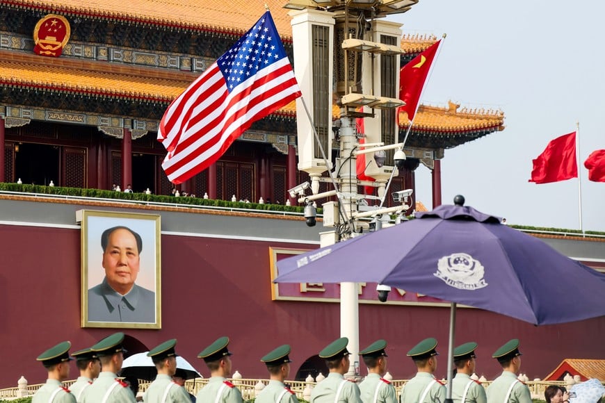 Paramilitary police officers line up in front of Tiananmen Gate as U.S. and China’s national flags fly in the wind next to the portrait of late Chinese Chairman Mao Zedong, ahead of U.S. President Donald Trump's visit to China, in Beijing, China, May 13, 2026. REUTERS/Maxim Shemetov