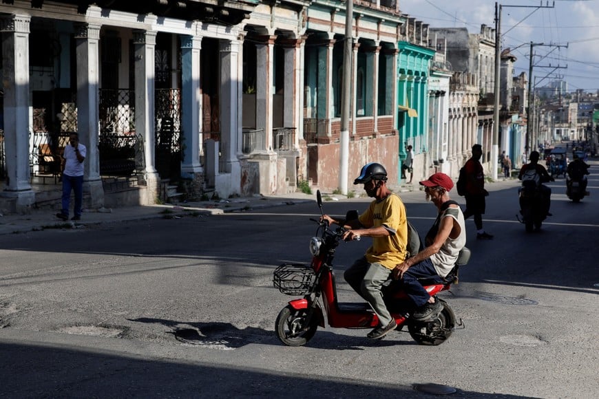 Men ride on an electric scooter as Cuba's electrical grid suffered a partial collapse early Thursday morning, cutting power across eastern Cuba amid a U.S. fuel blockade, in Havana, Cuba, May 14, 2026. REUTERS/Norlys Perez