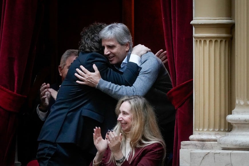 Argentina's President Javier Milei and Minister of Economy Luis Caputo embrace, as General Secretary of the Presidency Karina Milei reacts, on the day Argentina's Cabinet Chief Manuel Adorni presents his management report at the National Congress, in Buenos Aires, Argentina, April 29, 2026. REUTERS/Mariana Nedelcu