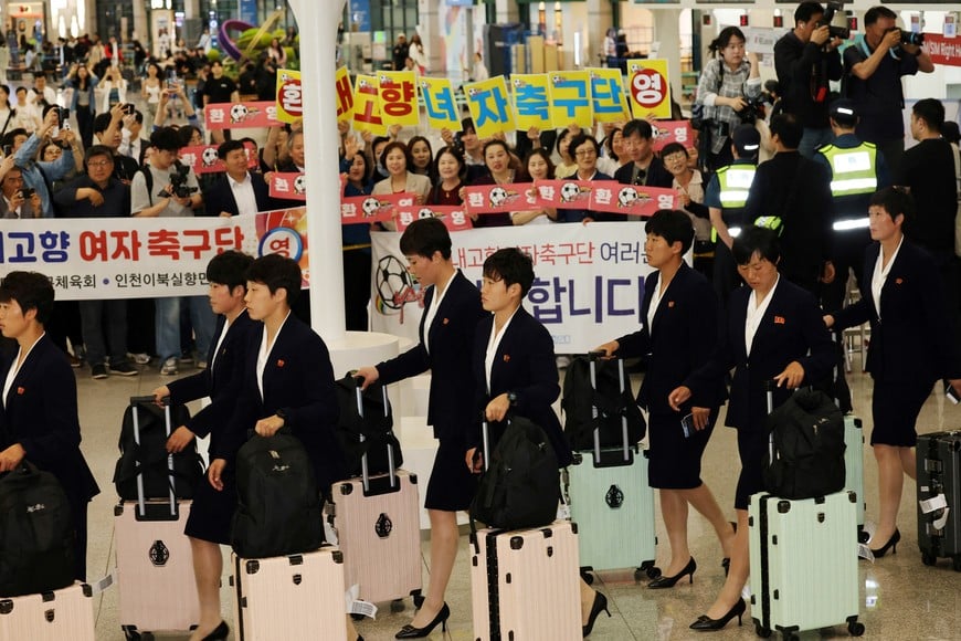 Members of North Korean soccer club Naegohyang Women’s FC walk past activists cheering them as they arrive at Incheon International Airport for a match against South Korea's Suwon FC Women on May 20, in Incheon, South Korea, May 17, 2026.     REUTERS/Kim Hong-Ji
