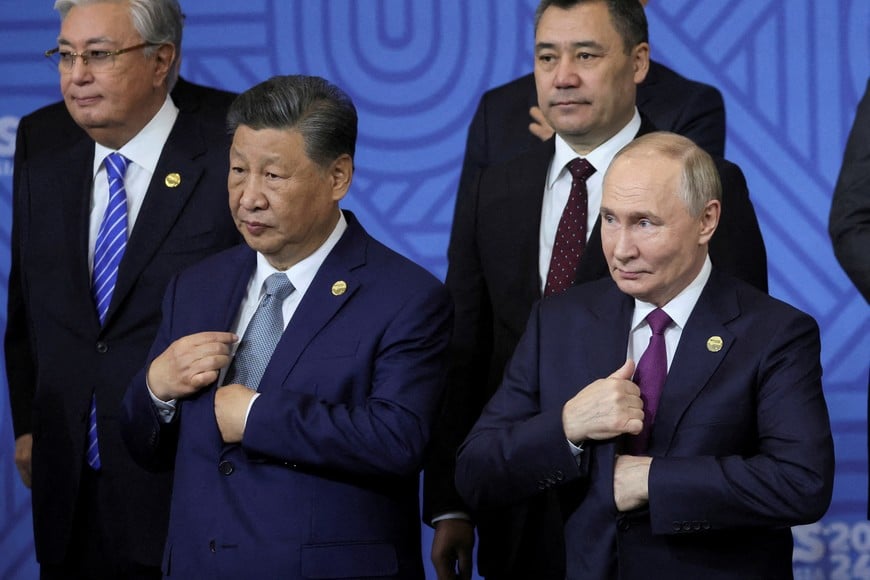 Russian President Vladimir Putin stands with Chinese President Xi Jinping as other participants in the outreach/BRICS Plus format meeting pose for a family photo during the BRICS summit in Kazan, Russia, 24 October 2024. MAXIM SHIPENKOV/Pool via REUTERS REFILE - QUALITY REPEAT      TPX IMAGES OF THE DAY