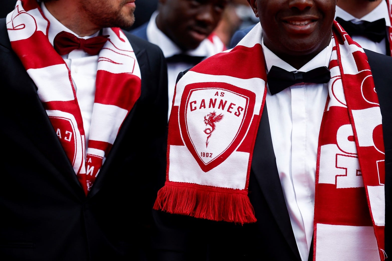 Miembros del club de fútbolAS Cannes usando sus bufandas.