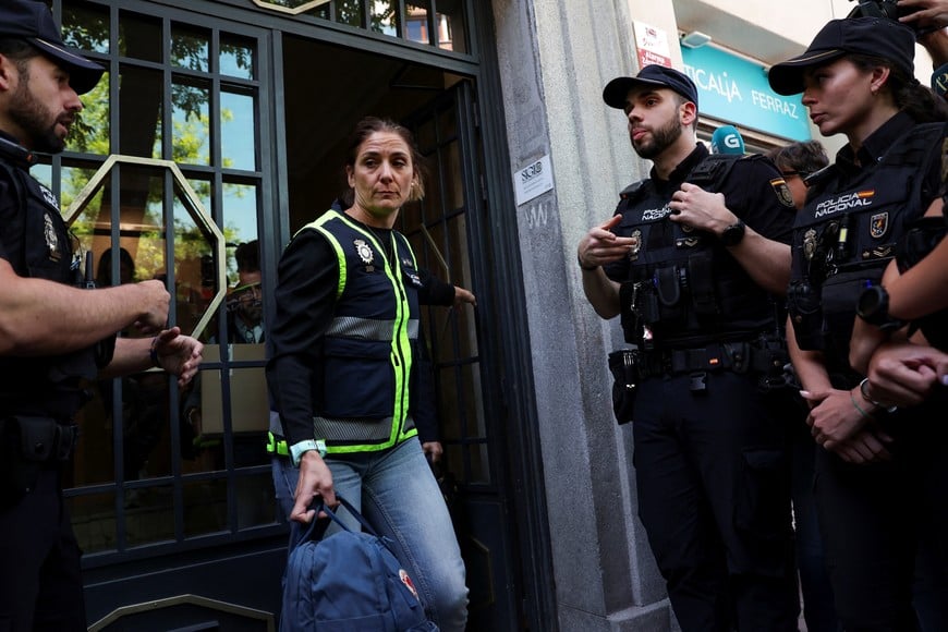 A police officer carries a backpack from the office of former Spanish Prime Minister Jose Luis Rodriguez Zapatero, who, according to the country's High Court, is being investigated for alleged influence peddling and related crimes, in Madrid, Spain, May 19, 2026. REUTERS/Violeta Santos Moura