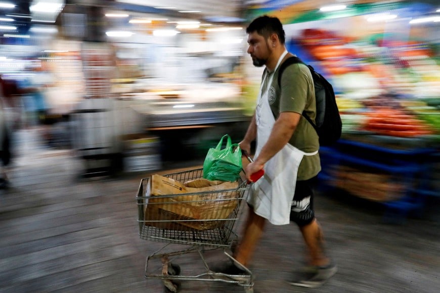 FILE PHOTO: A butcher walks with a shopping cart at a local market, as Argentina's annual inflation rate tore past 100% in February, the country's statistics agency said on Tuesday, the first time it has hit triple figures since a period of hyperinflation in 1991, over three decades ago, in Buenos Aires, Argentina March 14, 2023. REUTERS/Agustin Marcarian/File Photo