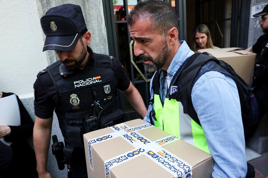Police officers carry boxes from the office of former Spanish Prime Minister Jose Luis Rodriguez Zapatero, who, according to the country's High Court, is being investigated for alleged influence peddling and related crimes, in Madrid, Spain, May 19, 2026. REUTERS/Violeta Santos Moura