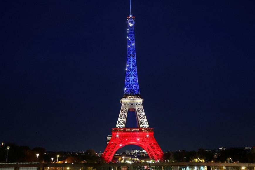 The Eiffel Tower is lit up with the blue, white and red colours of the French flag to mark the tenth anniversary of the November 13 Paris attacks, in Paris, France November 12, 2025. REUTERS/Abdul Saboor TPX IMAGES OF THE DAY
