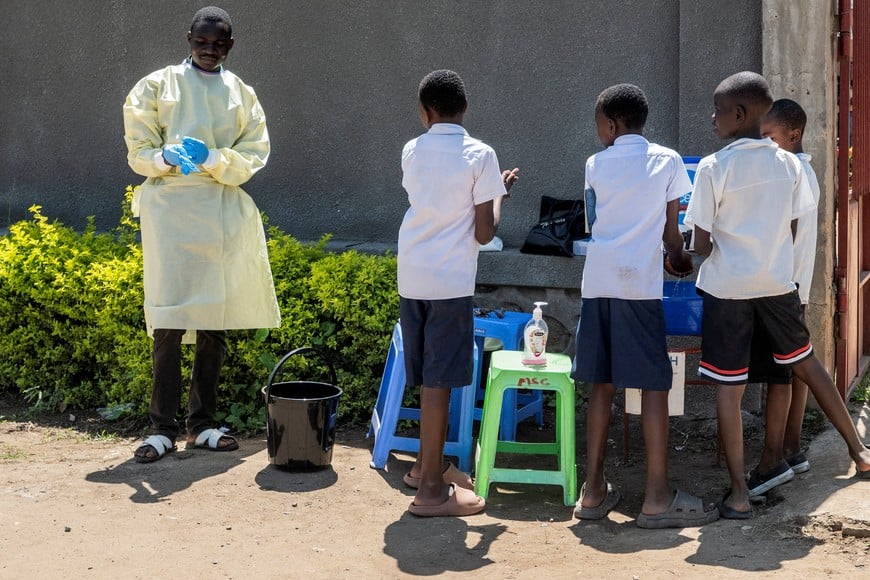 A Congolese health worker prepares a hand washing station for students to utilize, as authorities intensify efforts to contain a new Ebola outbreak involving the Bundibugyo strain, along a street in Bunia, Ituri province, Democratic Republic of Congo, May 22, 2026. REUTERS/Stringer