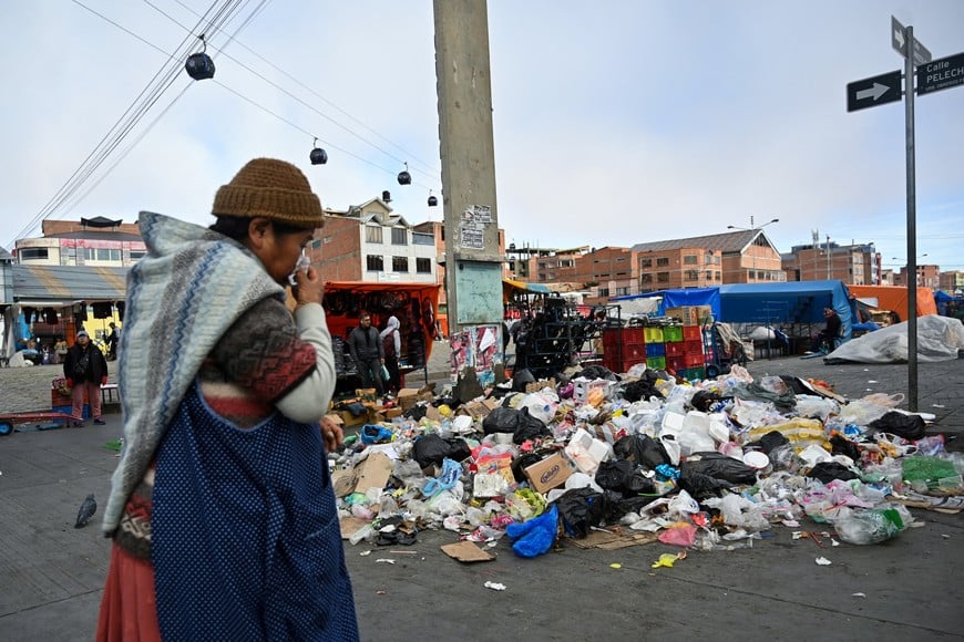 A person walks past piles of garbage accumulated due to blockades and protests calling for the resignation of Bolivia's President Rodrigo Paz, as the country's economic and fuel crisis worsens due to a shortage of U.S. dollars and falling domestic energy production, in El Alto, Bolivia, May 21, 2026. REUTERS/Claudia Morales