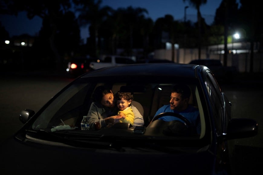 Hernando Morales, his wife Ines Pedroza, and their son Lucas, sit in their car outside a temporary shelter in Garden Grove, after being evacuated from the area following evacuations prompted by a failing chemical tank containing methyl methacrylate, a flammable liquid used in the aerospace industry, in California, U.S., May 22, 2026. REUTERS/Ed Ou
