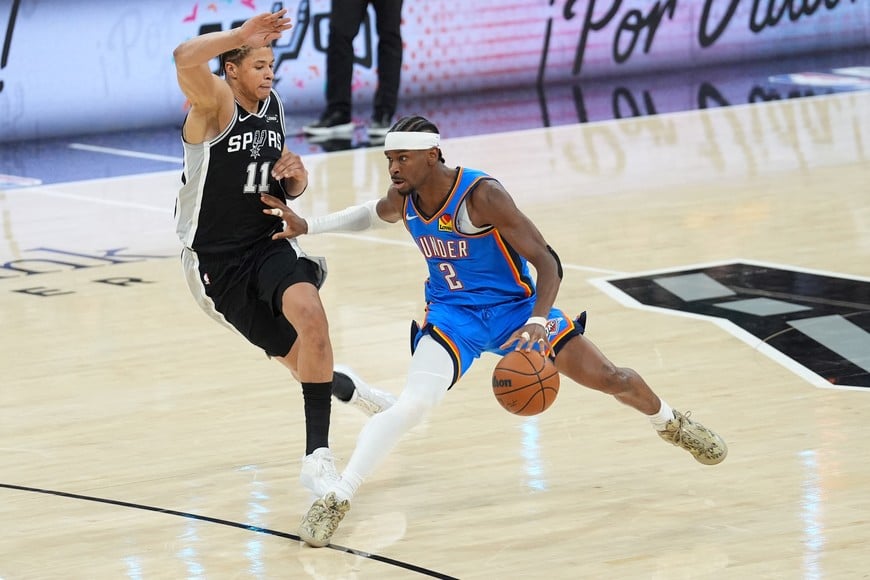 May 22, 2026; San Antonio, Texas, USA; Oklahoma City Thunder guard Shai Gilgeous-Alexander (2) dribbles the ball past San Antonio Spurs forward Carter Bryant (11) in the first half during game three of the western conference finals for the 2026 NBA playoffs at Frost Bank Center. Mandatory Credit: Daniel Dunn-Imagn Images