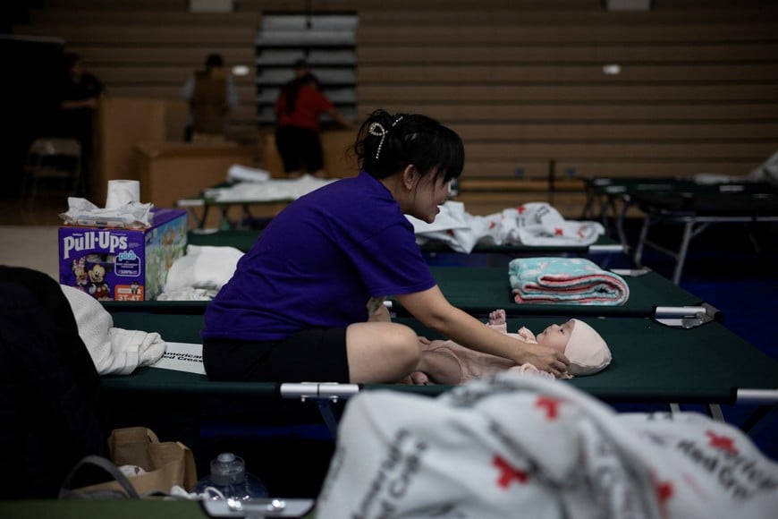 Hoang Vo changes the diaper of her 2-month-old daughter, Christina, at a shelter following an evacuation order issued on Friday for an area in nearby Garden Grove after officials warned that a tank of hazardous chemicals could rupture or explode, in Huntington Beach, California, U.S., May 24, 2026. REUTERS/Ed Ou