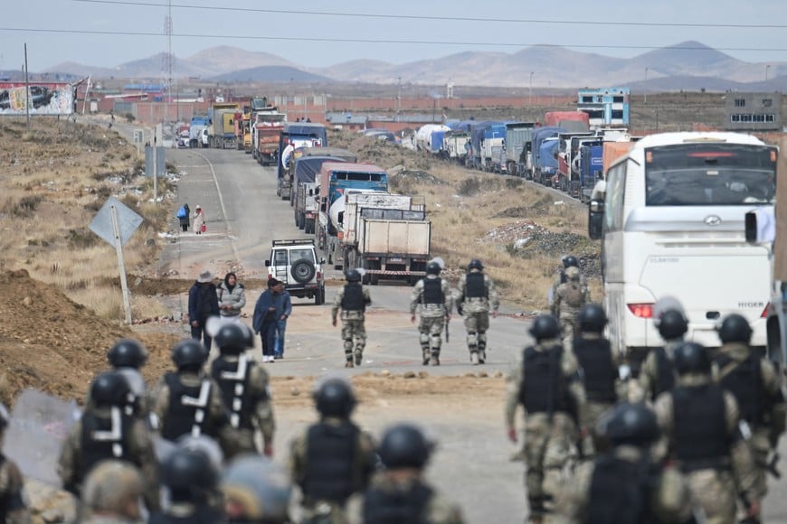 Trucks are stopped and waiting to be unblocked while security personnel try to open "humanitarian corridors" amid nationwide protests aiming to press Bolivian President Rodrigo Paz's government to roll back austerity measures and address rising costs of living, in Apacheta, Bolivia, May 23, 2026. REUTERS/Claudia Morales