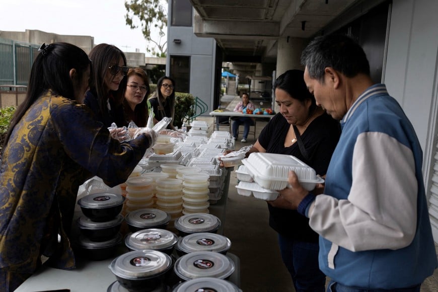 Thu-Ha Nguyen (3rd L) and Trang Luong (2nd L) help serve food at a shelter to evacuees following an evacuation order issued on Friday for an area in nearby Garden Grove after officials warned that a tank of hazardous chemicals could rupture or explode, in Huntington Beach, California, U.S., May 24, 2026. REUTERS/Ed Ou