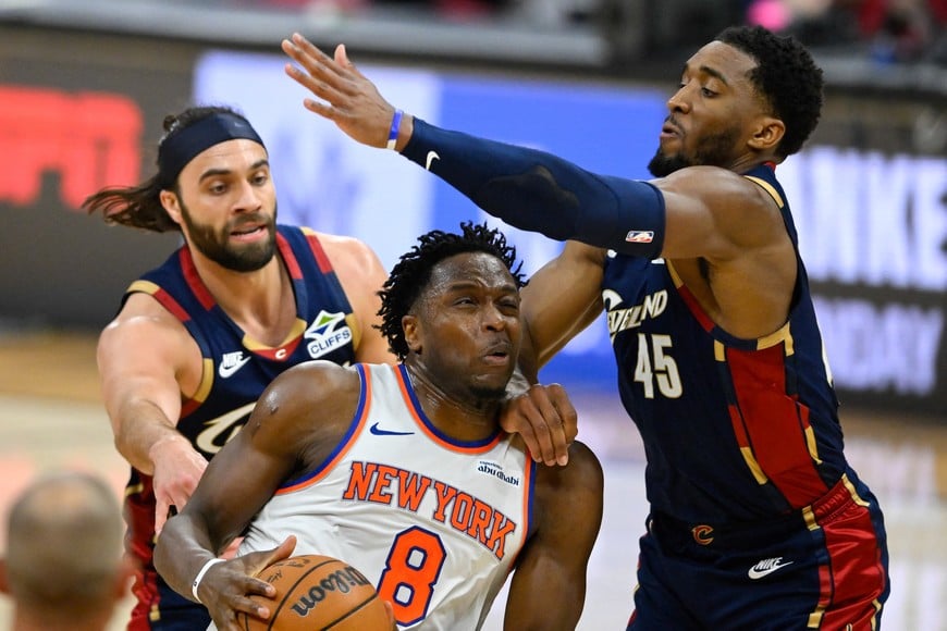 May 23, 2026; Cleveland, Ohio, USA; New York Knicks forward OG Anunoby (8) drives the ball between Cleveland Cavaliers guard Max Strus (2) and guard Donovan Mitchell (45) in the second quarter during game three of the eastern conference finals for the 2026 NBA playoffs at Rocket Arena. Mandatory Credit: David Richard-Imagn Images