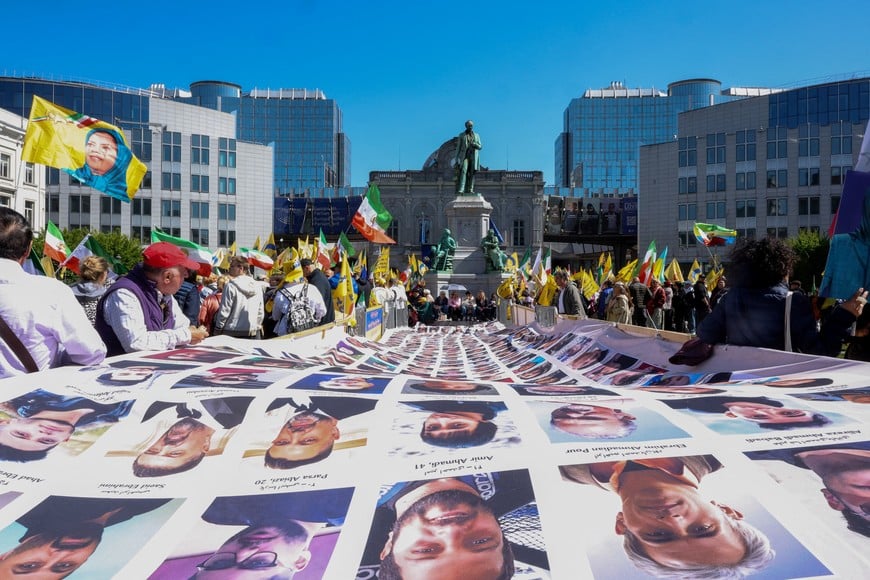 Demonstrators gather around a large banner with images of people killed during the recent anti-government protests in Iran, as Iranians and supporters of the National Council of Resistance of Iran (NCRI) take part in a rally calling for the European Union's action against what organisers call political executions in Iran, ahead of European Union leaders' summit, in Brussels, Belgium April 22, 2026. REUTERS/Omar Havana TPX IMAGES OF THE DAY