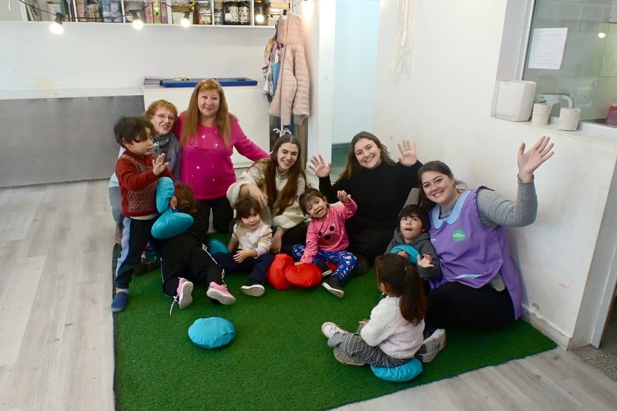 Entre libros, miradas y sonrisa, las abuelas junto a funcionarias municipales, la seño Nati -que celebra su día- y los pequeños de 3 años. Foto: Flavio Raina