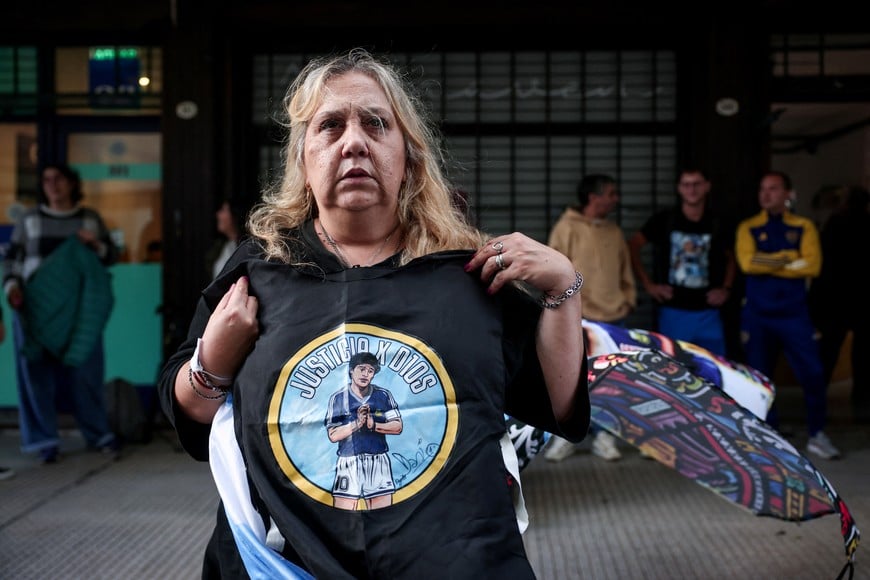 A woman holds a t-shirt with an image of late Argentine soccer legend Diego Armando Maradona, on the day his personal doctor Leopoldo Luque is expected to attend a new trial against medical professionals facing accusations of negligence in connection to the 2020 death of the global icon, in Buenos Aires, Argentina, April 14, 2026. REUTERS/Cristina Sille
