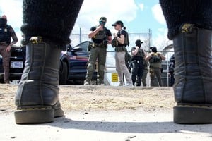 Un manifestante se enfrenta a agentes del Servicio de Inmigración y Control de Aduanas de Estados Unidos (ICE) y agentes federales que custodian la entrada del centro de detención Delaney Hall. Foto: REUTERS / Eduardo Muñoz.