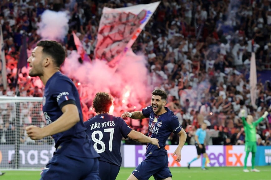 Soccer Football - UEFA Champions League - Final - Paris St Germain v Arsenal - Puskas Arena, Budapest, Hungary - May 30, 2026
Paris St Germain's Joao Neves and Lucas Beraldo celebrate after winning the penalty shoot out as fans set off flares in the stand REUTERS/Bernadett Szabo