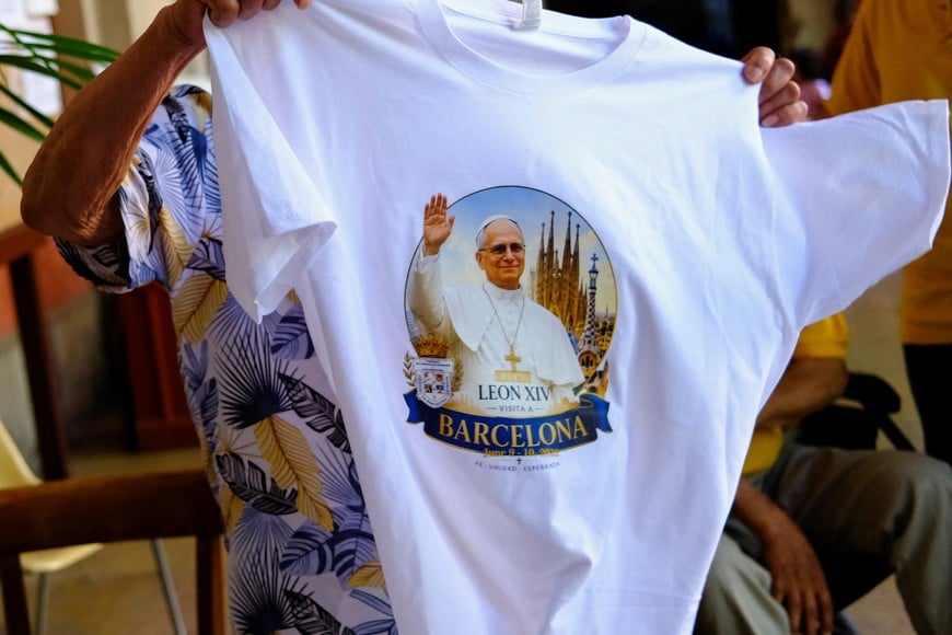 A faithful holds a T-shirt with an image of Pope Leo XIV before a Mass at Saint Augustine church, also known as the "Church of the Migrants", ahead of Pope Leo XIV's visit to Barcelona, in Barcelona's Raval neighbourhood, Spain, May 31, 2026. REUTERS/Nacho Doce
