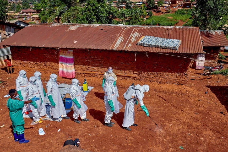 FILE PHOTO: Red Cross workers wearing personal protective equipment walk in a formation as they disinfect the ground outside the house of an unidentified man who died of Ebola, before retrieving his body, as aid agencies intensify efforts to contain a new Ebola outbreak involving the Bundibugyo strain, in Quartier Shuni 1, a residential sector in Mongbwalu, Djugu Territory of Ituri province, Democratic Republic of Congo, May 24, 2026. REUTERS/Gradel Muyisa Mumbere/File Photo