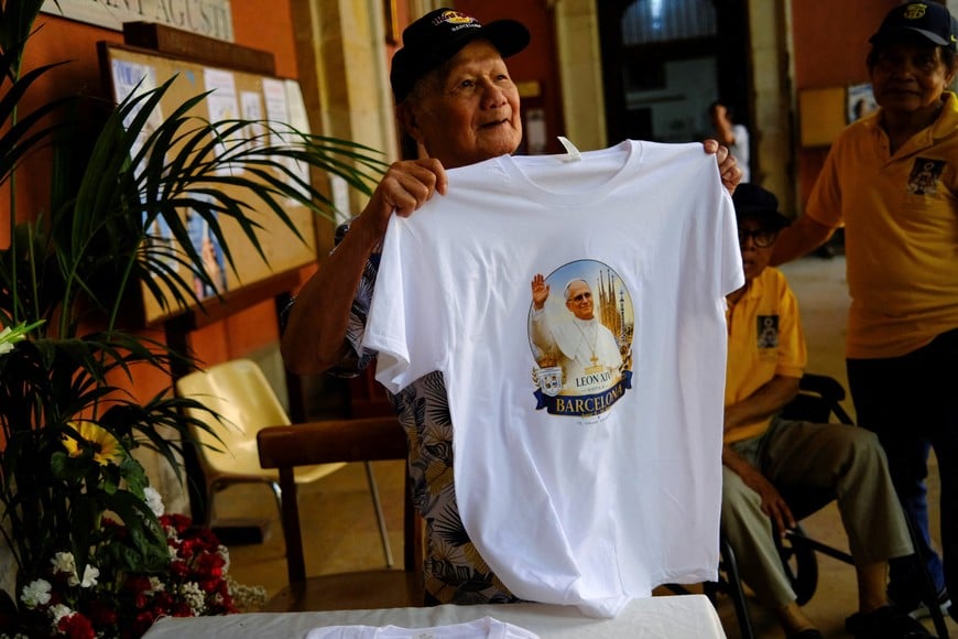 A faithful holds a T-shirt with an image of Pope Leo XIV before a Mass at Saint Augustine church, also known as the "Church of the Migrants", ahead of Pope Leo XIV's visit to Barcelona, in Barcelona's Raval neighbourhood, Spain, May 31, 2026. REUTERS/Nacho Doce