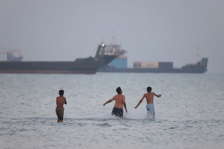 People walk in water, as vessels in the Strait of Hormuz are visible, near the beach of Bandar Abbas, Iran, May 31, 2026. Amirhosein Khorgooi/ISNA/WANA (West Asia News Agency) via REUTERS ATTENTION EDITORS - THIS PICTURE WAS PROVIDED BY A THIRD PARTY ATTENTION EDITORS - THIS PICTURE WAS PROVIDED BY A THIRD PARTY. ISRAEL OUT. NO COMMERCIAL OR EDITORIAL SALES IN ISRAEL. NO ACCESS FOR ISRAELI MEDIA. NO USE BBC PERSIAN. NO USE VOA PERSIAN. NO USE MANOTO. NO USE IRAN INTERNATIONAL. NO USE RADIO FARDA. DIGITAL: NO USE BBC PERSIAN. NO USE VOA PERSIAN. NO USE MANOTO. NO USE IRAN INTERNATIONAL. NO USE RADIO FARDA.