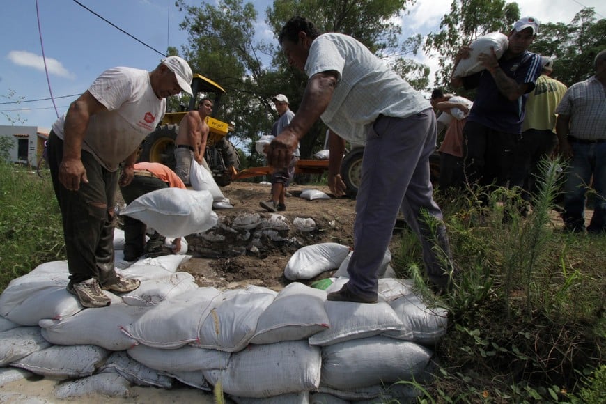 Vecinos organizados junto a agentes comunales trataban de frenar el avance de la crecida, en Rincón Norte, durante la inundación de 2015.

Mauricio Garín (Archivo).