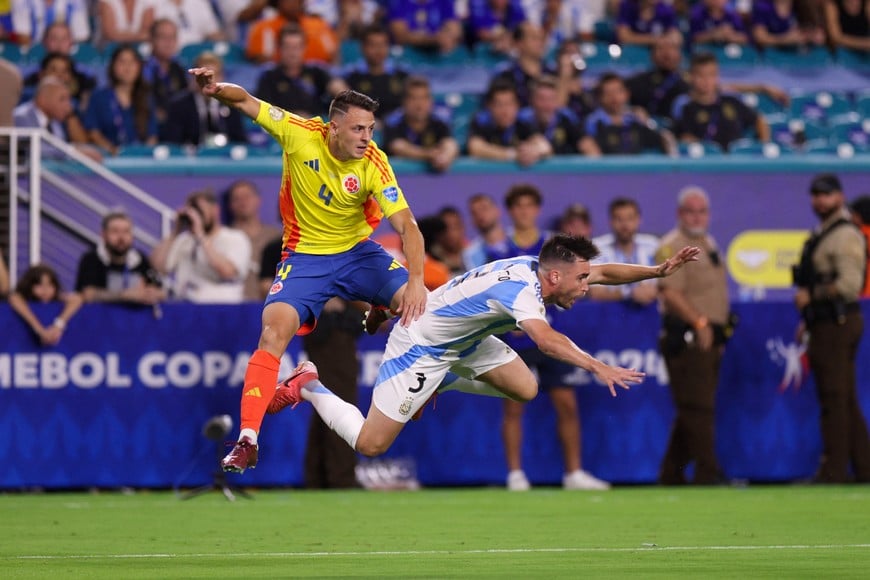 Jul 14, 2024; Miami, FL, USA;  Argentina defender Nicolas Tagliafico (3) and Colombia midfileder Santiago Arias (4) collide in the first half during the Copa America Final at Hard Rock Stadium. Mandatory Credit: Nathan Ray Seebeck-USA TODAY Sports