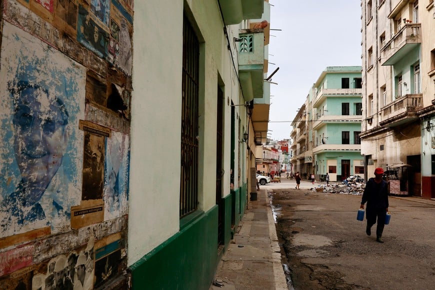 A man walks on a street and near a photo of Cuba's former President Raul Castro as the country marks Castro's 95th birthday after U.S. authorities charged him with murder in connection with the downing of civilian airplanes in 1996 and amid sanctions and a fuel blockade by the administration of U.S. President Donald Trump, in Havana, Cuba, June 3, 2026. REUTERS/Norlys Perez