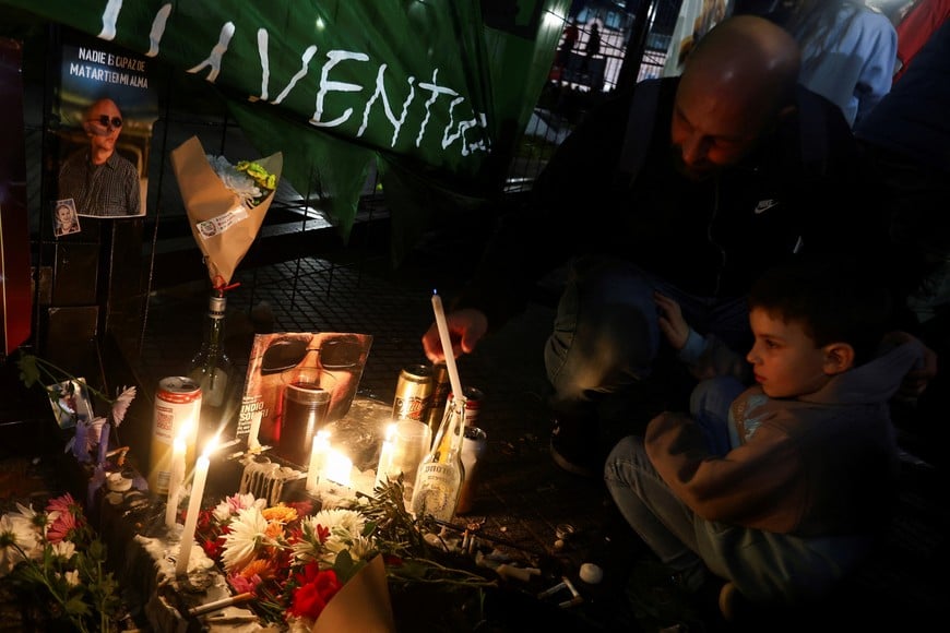 A man lights a candle as fans of Argentine singer Carlos Alberto Solari, also known as Indio Solari, gather at Plaza de Mayo for a tribute, on the day of his death, in Buenos Aires, Argentina, June 5, 2026. REUTERS/Matias Baglietto