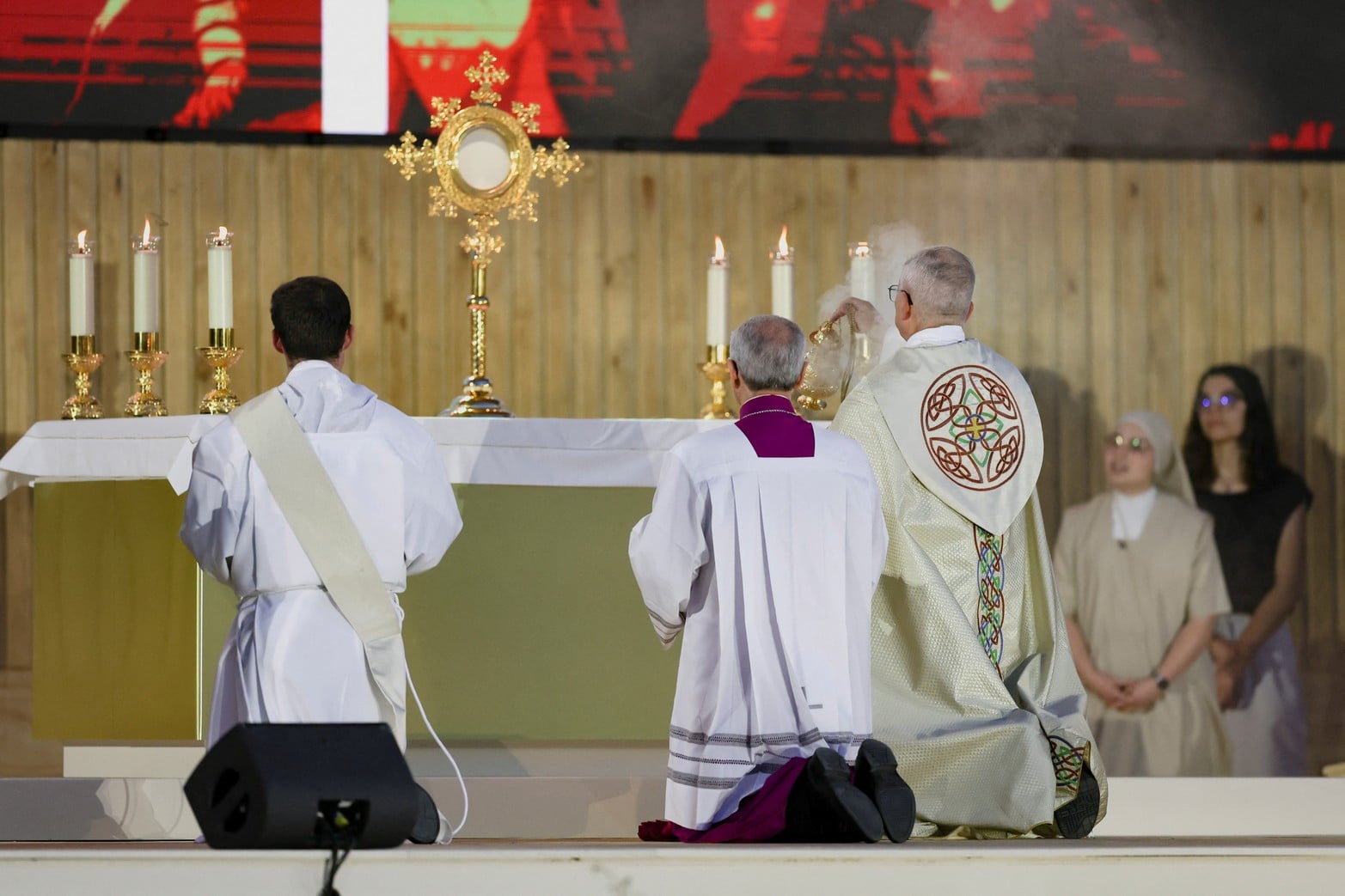 El papa León XIV se arrodilla durante una vigilia de oración en la Plaza de Lima durante su viaje apostólico en Madrid.