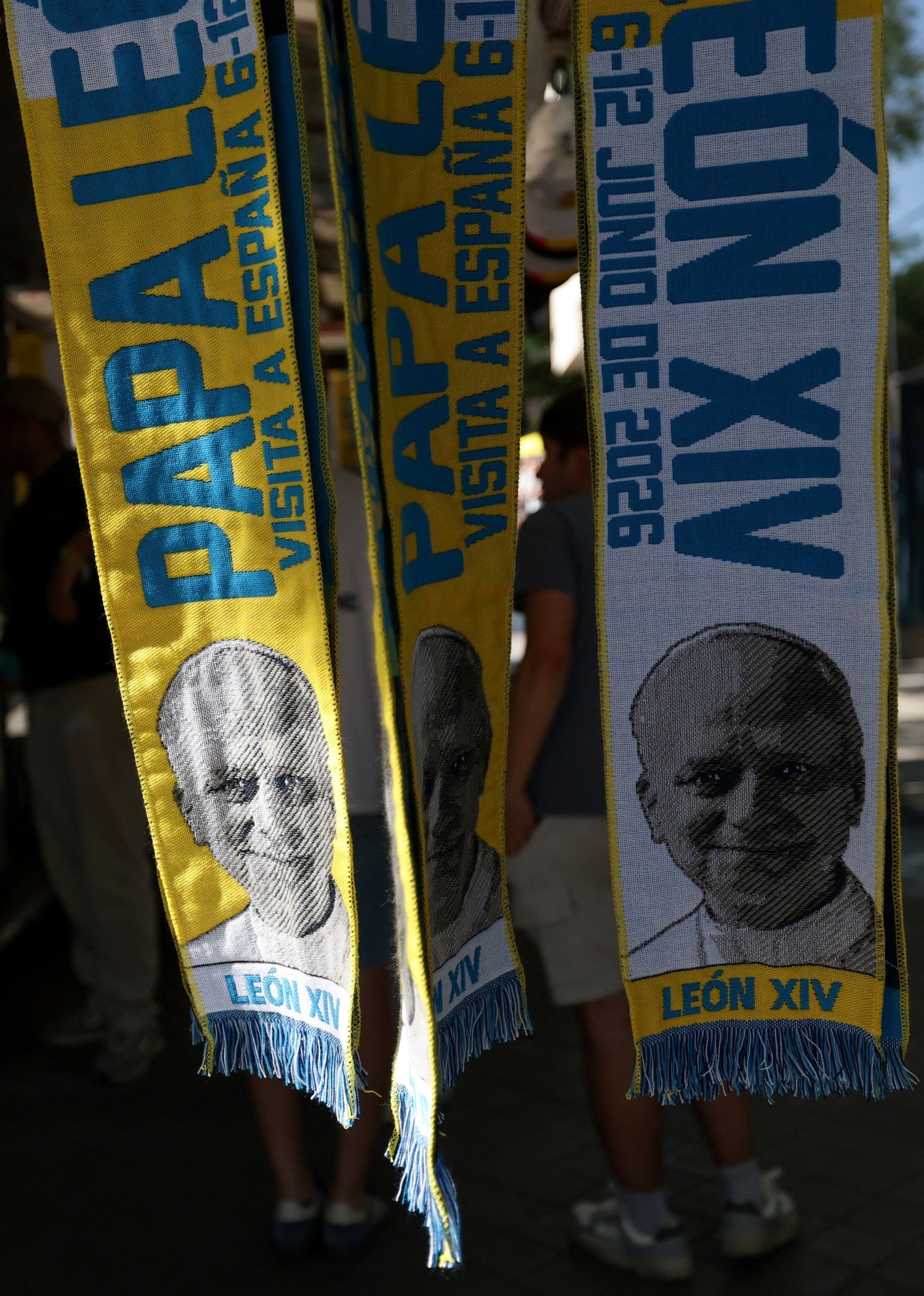 Bufandas con imágenes del Papa León XIV se exhiben durante su viaje apostólico en Madrid.