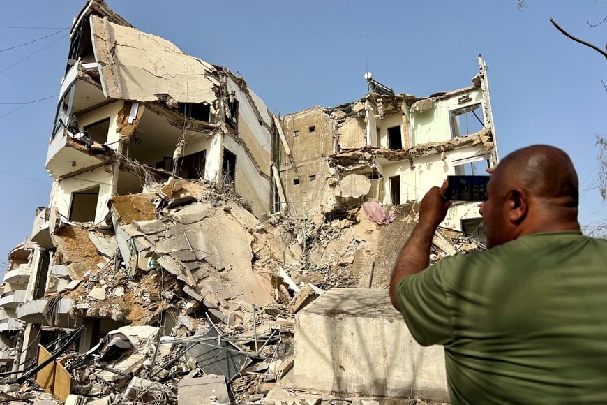 (260405) -- BEIRUT, 5 abril, 2026 (Xinhua) -- Imagen del 4 de abril de 2026 de un hombre tomando fotografías de edificios dañados después de los ataques aéreos israelíes, en Tiro, Líbano. Los ataques aéreos y ataques con drones israelíes en el sur de Líbano dejaron al menos 14 muertos y más de 25 heridos, según informó la Agencia Nacional de Noticias, mientras aviones de guerra israelíes llevaban a cabo intensos ataques aéreos en los suburbios del sur de Beirut el sábado al amanecer y durante la mañana. (Xinhua/Ali Hashisho) (rtg) (ah)