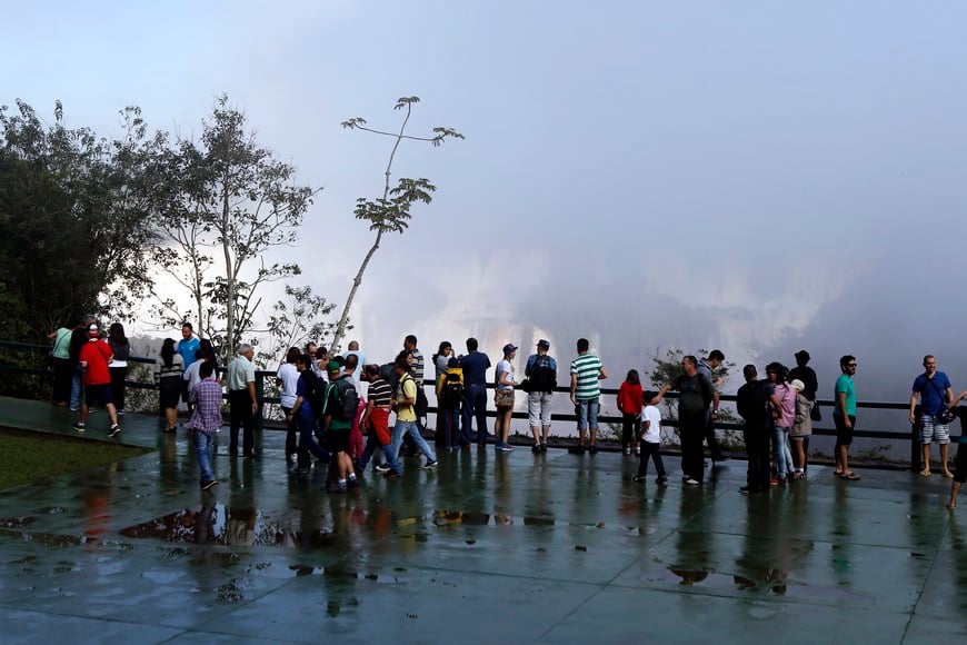 Tourists view the Iguazu Falls from an observation platform at the Iguazu National Park near the southern Brazilian city of Foz do Iguacu June 16, 2014. Forming a border between Argentina and Brazil, the Iguazu Falls, South America's largest falls, attract more than 1 million visitors a year. REUTERS/Jorge Adorno (BRAZIL - Tags: ENVIRONMENT SOCIETY TRAVEL) brasil foz de iguazu crecida record del rio parana cataratas del iguazu con caudal record de agua