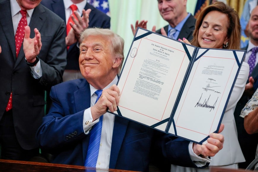 U.S. President Donald Trump holds up the Secure America Act after signing it in the Oval Office at the White House in Washington, D.C., U.S., June 10, 2026. REUTERS/Evan Vucci