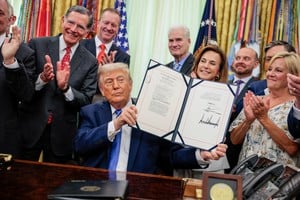 U.S. President Donald Trump holds up the Secure America Act after signing it in the Oval Office at the White House in Washington, D.C., U.S., June 10, 2026. REUTERS/Evan Vucci