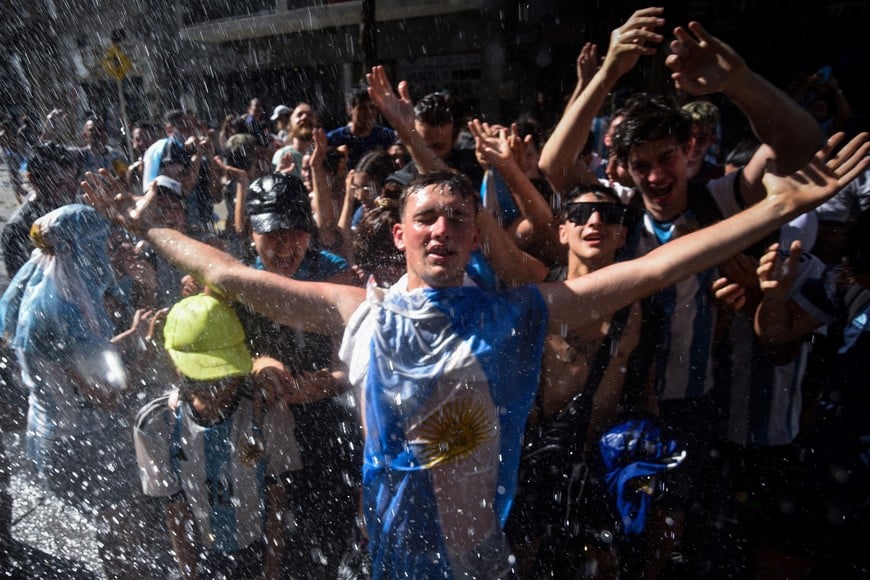 Soccer Football - FIFA World Cup Qatar 2022 - Argentina Victory Parade after winning the World Cup - Buenos Aires, Argentina - December 20, 2022
An Argentina fan wearing the Argentina flag celebrates among fans at the Obelisco after the victory parade was cancelled and Argentina players departed REUTERS/Mariana Nedelcu