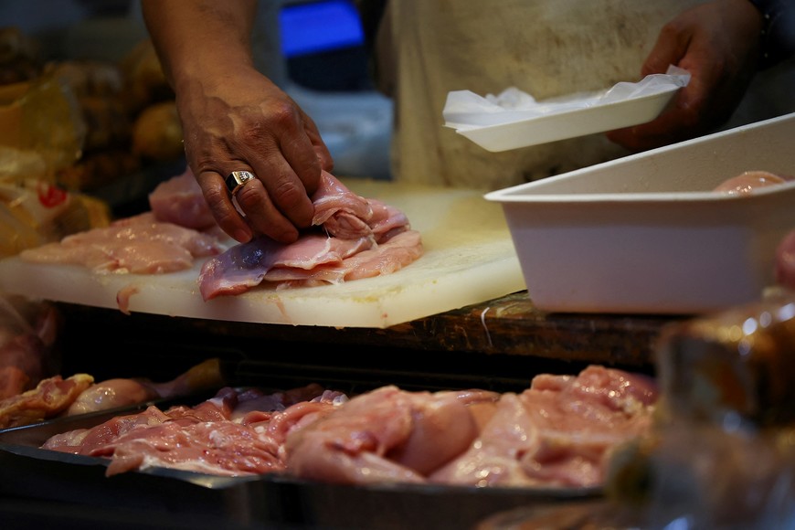 A butcher picks chicken slices in a local market, as Argentines ate more poultry per capita than beef in 2024, official data show that consumption of the red meat slid amid high inflation and tough austerity under libertarian President Javier Milei, in Buenos Aires, Argentina January 23, 2025. REUTERS/Agustin Marcarian