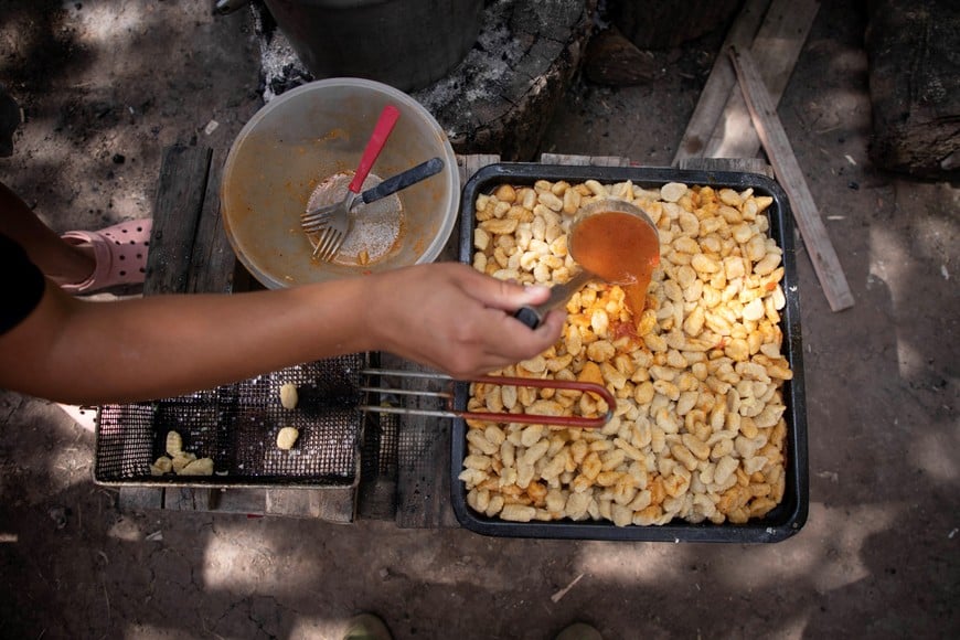 (240130) -- MORENO, 30 enero, 2024 (Xinhua) -- Imagen del 29 de enero de 2024 de una voluntaria del comedor y merendero popular llamado Génesis colocando salsa a una fuente con ñoquis de harina de maíz, en el partido de Moreno de la provincia de Buenos Aires, Argentina. Cada día más personas recurren en Argentina a los comedores comunitarios, frente a la agudización de la situación económica y en la búsqueda de una alternativa ante el elevado costo de la canasta alimentaria, constituyéndose estos espacios en refugios necesarios en medio de la crisis. (Xinhua/Martín Zabala) (mz) (jg) (ra) (vf)